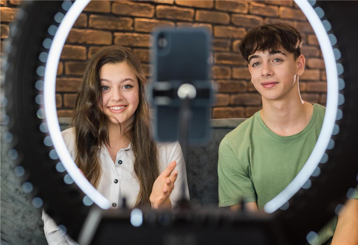 Garoto e garota em frente a equipamento de filmagem gravando para marketing de influência