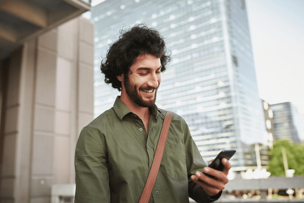 Homem sorridente realizando seu atendimento com um chatbot